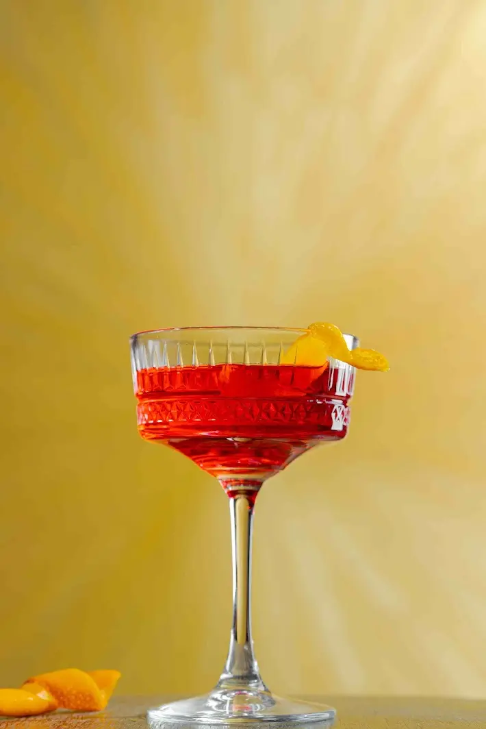Red Cambodian Negroni cocktail made with Herbal Kulen gin and garnished with orange peel.