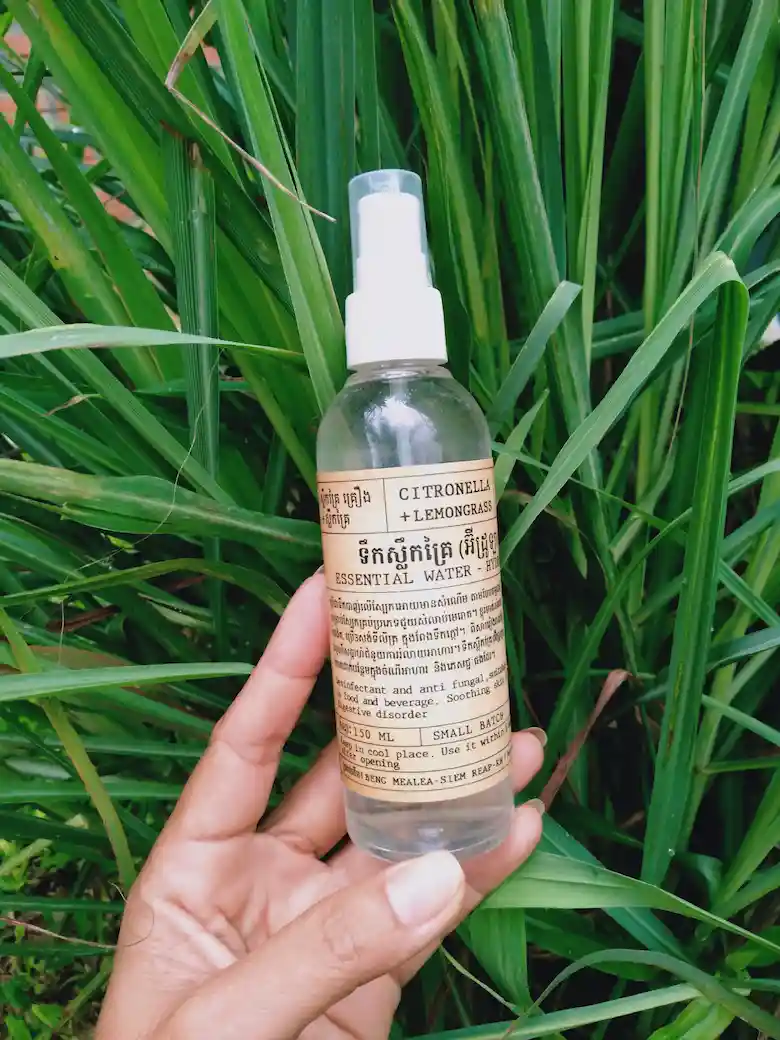 Herbal Kulen citronella and lemongrass essential water spray displayed in front of fresh green leaves.