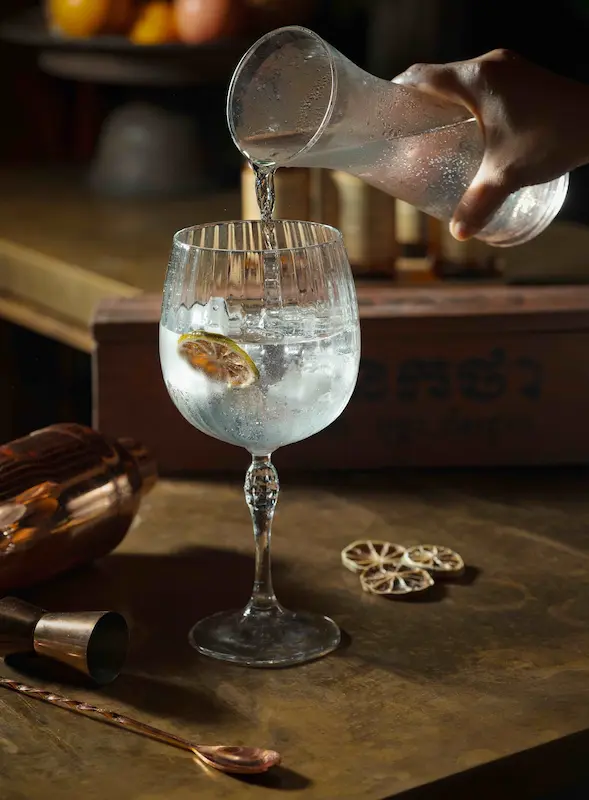 Herbal Kulen gin and soda served over ice with a dried citrus slice.