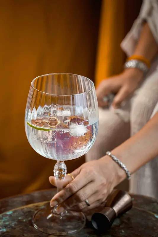 Herbal Kulen gin and tonic with ice and lime, served in an elegant balloon glass.