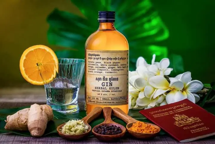 Herbal Kulen Cambodian gin displayed with citrus, ginger, spices and tropical flowers.