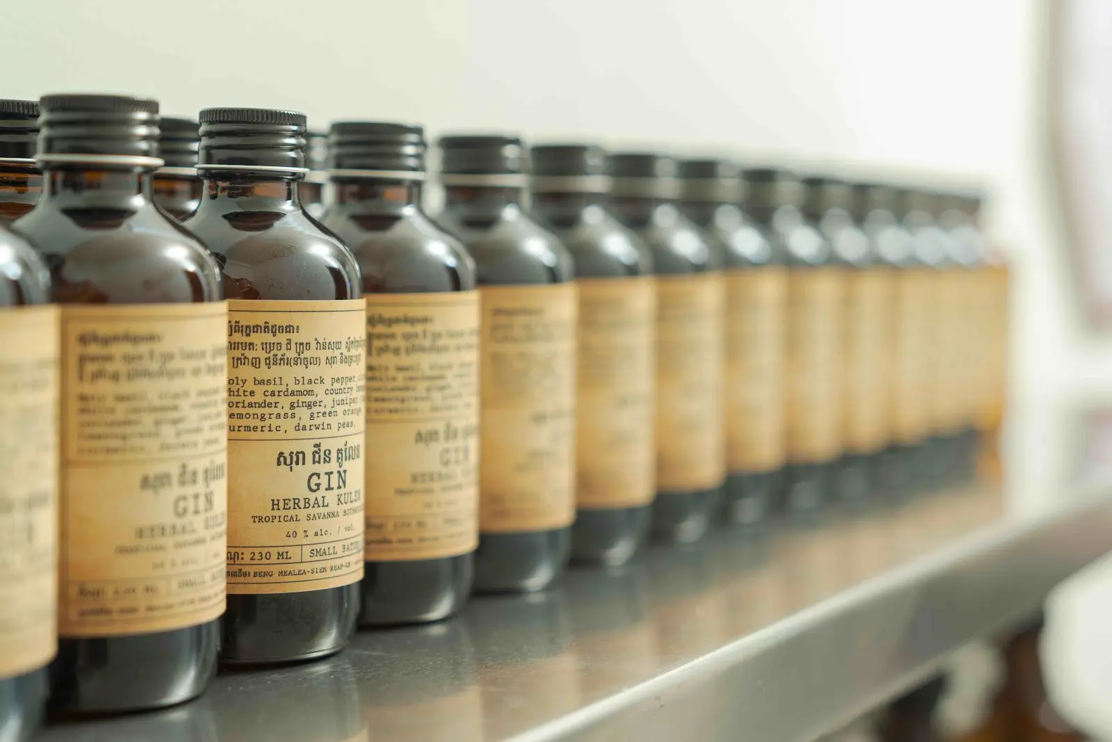 Rows of Herbal Kulen small-batch Cambodian gin bottles ready for production.