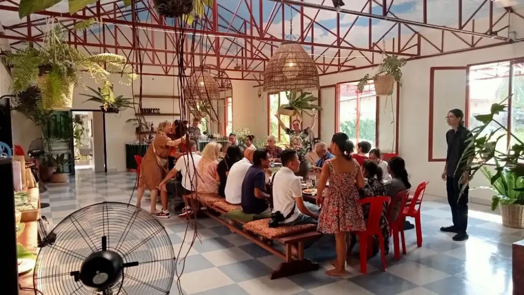 Guests gathering around a shared table during a Herbal Kulen gin tasting experience in Siem Reap.