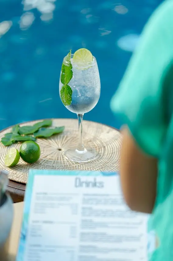 Refreshing Kafir gin cocktail with crushed ice, lime and fresh kaffir lime leaves by the pool.