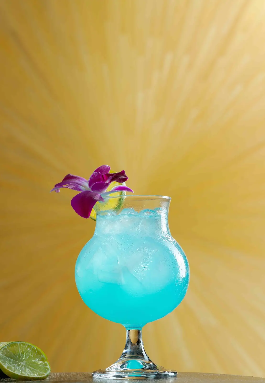 Bright blue Koh Rong cocktail with Herbal Kulen gin, lime and a purple orchid garnish.