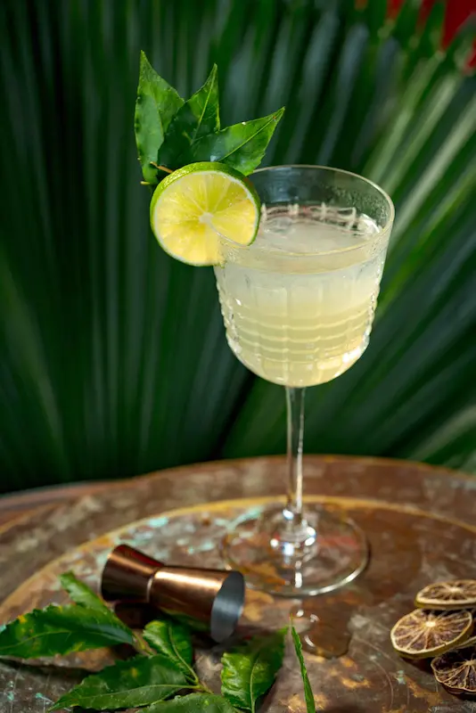 Pale citrus Mealea Bite cocktail made with Herbal Kulen gin and garnished with lime.