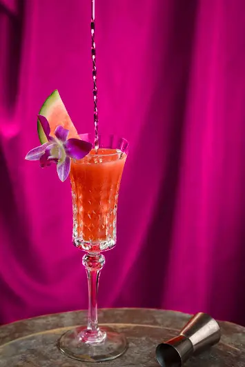 Red Carpet cocktail with Herbal Kulen gin, watermelon and a purple orchid garnish.