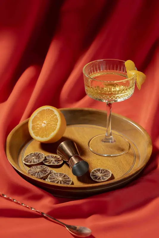 White Negroni cocktail with Herbal Kulen gin, citrus notes and an orange peel garnish.